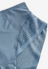 Material de activitate de culoare albastră deschisă, cu o textură netedă și un panou din plasă cu un model subtil. Design fără cusături, cu un talie largă.