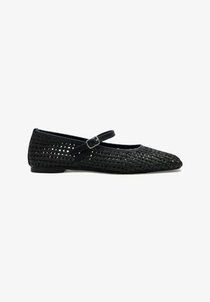 Zapato plano Mary Jane tejido en negro, con una correa delgada ajustable y hebilla, que presenta una punta redondeada y tacón bajo.