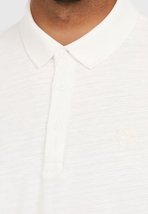 Uomo che indossa una polo bianca con colletto e bottoni, con un logo O'Neill discreto sul petto.