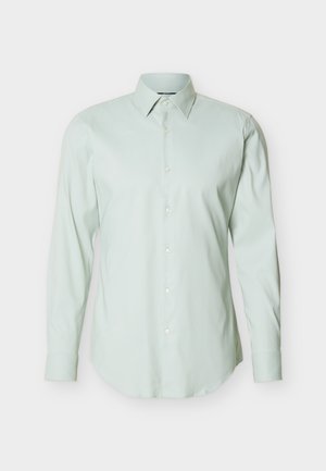 Ανοιχτοπράσινο ανδρικό πουκάμισο με μακριά μανίκια, κλειστό με κουμπιά και γιακά με μυτερές άκρες, σε απλό λευκό φόντο.