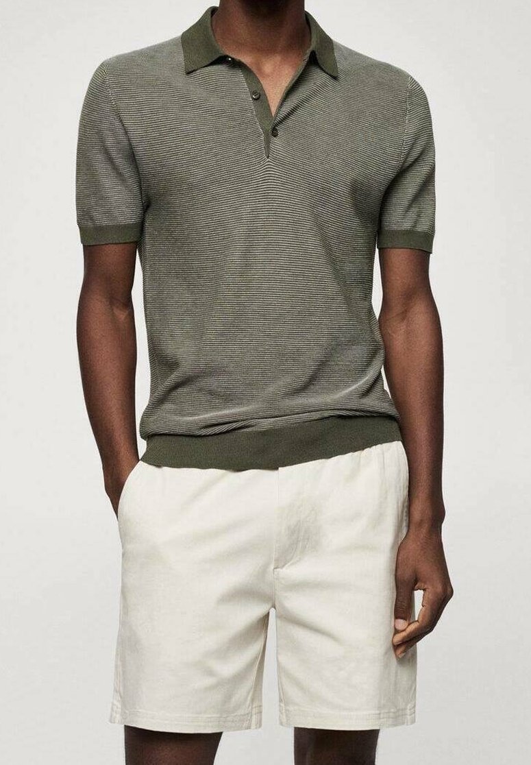 Polo shirt rayé vert olive avec un col et deux boutons, associé à un short couleur crème en tissu léger.