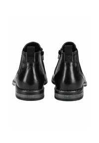 Schwarze Leder-Ankle-Boots mit glatter Oberfläche, seitlichem Reißverschluss, strukturiertem Rückenpanel und einer kontrastierenden braunen Sohle.