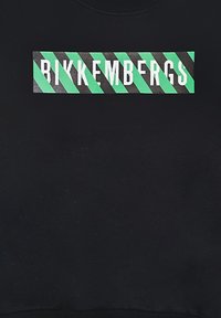 Tessuto nero con un logo rettangolare caratterizzato da strisce diagonali verdi e nere alternate e un testo bianco in grassetto che recita "Bikkembergs."