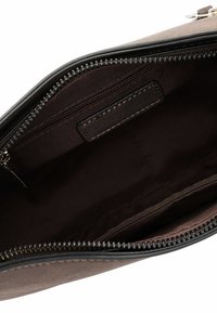 Brown leather handbag interior with a zipper, featuring a smooth texture, a small pocket, and a fabric lining. Simple, functional design.