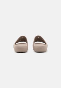 Zoccoli beige chiari con retro chiuso e ampie aperture. Realizzati in materiale leggero con fori di ventilazione e suola testurizzata.