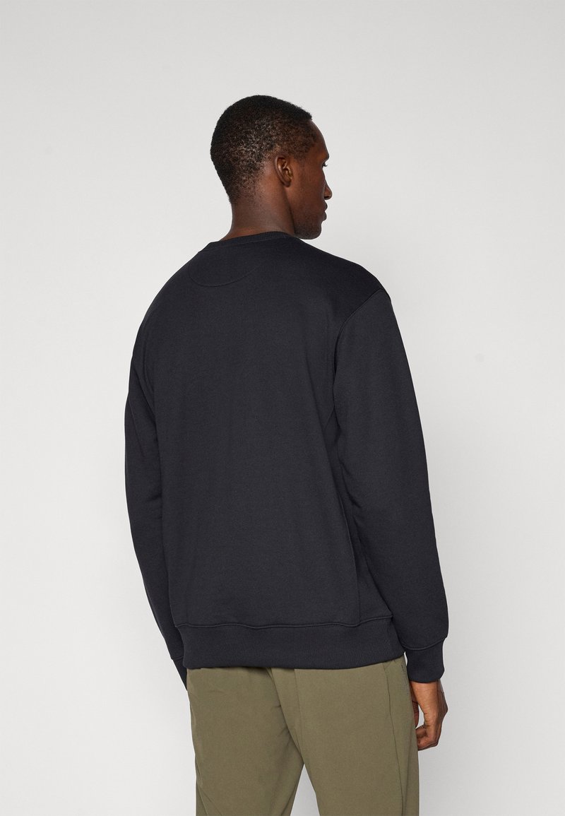 Sweatshirt noir en mélange de coton, avec des manches longues, des poignets côtelés et un col rond. Texture lisse, sans motifs ni logos visibles.