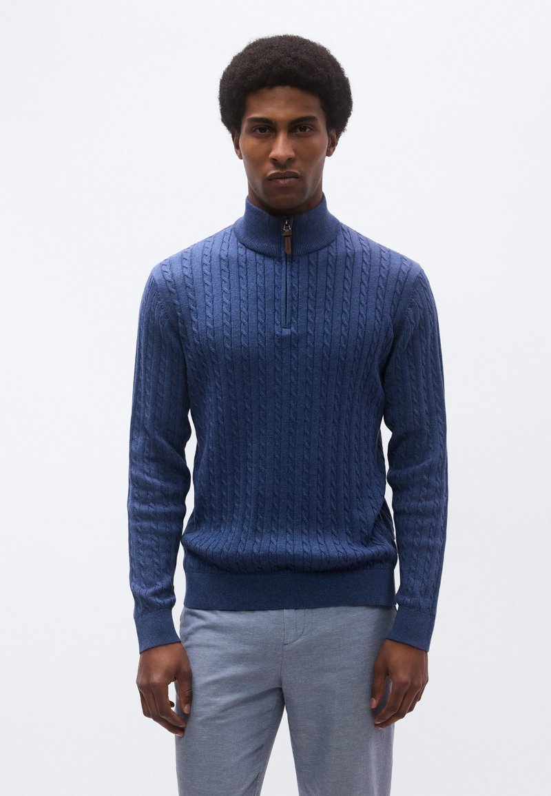 Πλεκτό πουλόβερ σε ναυτικό μπλε με ψηλό γιακά, διαθέτει φερμουάρ στο χρώμα αντίθεσης στο ένα τέταρτο του μήκους και ριμπ μανσέτες και τελείωμα.