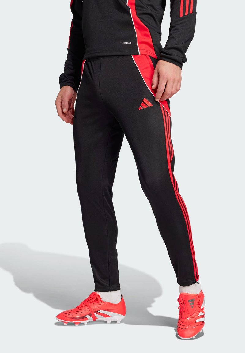 Zwarte sportbroek met rode zijstrepen en accenten, gemaakt van een glad, rekbaar materiaal. Kenmerkt zich door een aansluitend ontwerp met een taps toelopende pijp.
