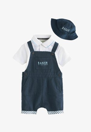 Marinblå overalls i en struktureret stof, justerbare stropper og to lommer, parret med en hvid skjorte med krave og en matchende hat.