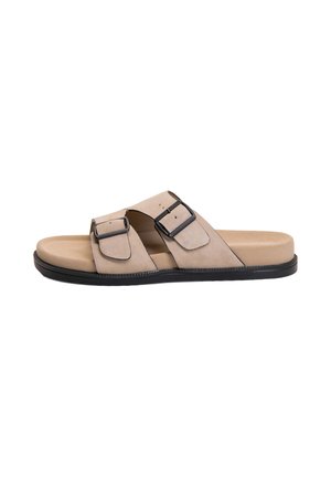 Sandale beige à enfiler avec deux brides noires ajustables à boucle et une semelle noire, vue de côté sur fond blanc.