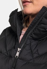 Czarna kurtka puchowa z wysokim kołnierzem, z zamkiem błyskawicznym i teksturowanym materiałem. Detal logo na klatce piersiowej. Wnętrze ma jasnoróżową podszewkę.