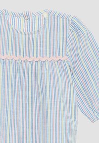 Gestreiftes Baumwollkleid mit blauen, gelben und roten Linien. Akzentuiert mit pinkfarbener, gewellter Borte am Oberteil. Runder Ausschnitt mit Knopfverschluss hinten.