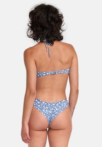 Blauwe bloemenbikini met halternek en verstelbare strik, naadloos ontwerp met hoge uitsnijding en witte bloemenpatronen.