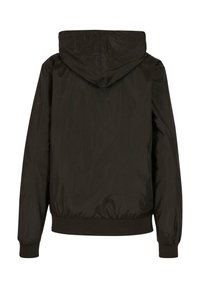 Black hooded jacket made of smooth, water-resistant material. Features a relaxed fit, ribbed cuffs, and a hem with elastic detailing.