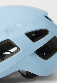 Un gros plan d'un casque de cyclisme Kask bleu, mettant en avant sa surface lisse, ses ouvertures de ventilation et les détails de branding.