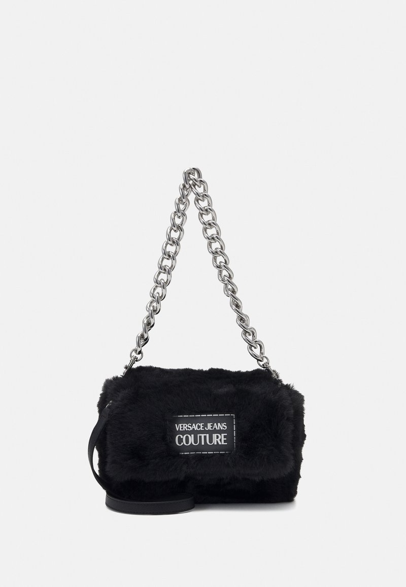 Sac à main en fausse fourrure noire avec poignée chaîne argentée et écusson logo "Versace Jeans Couture" sur le devant.