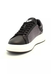 Svart och grå sneaker med svarta skosnören, mönstrade sidopaneler och tjock vit sula visad från framvinkeln.