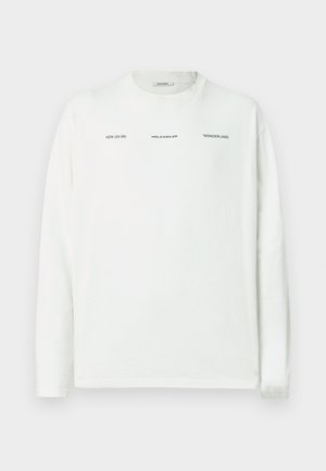 Pitkähihainen valkoinen puuvillainen t-paita, jossa mustalla painettu teksti. Pyöreä kaula-aukko, rento malli, sileä pinta, suora helma.