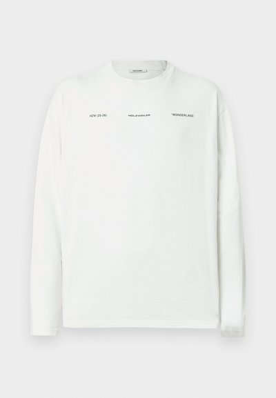 Camiseta de algodão branca de manga comprida, com detalhes de texto impressos a preto. Decote redondo, corte descontraído, textura suave, bainha reta.