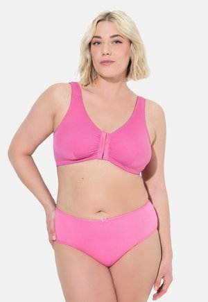 Rosa bh med blødt stof, brede stropper og lukning foran. Matchende rosa trusser med en lille sløjfedetalje ved taljen, sømløst design.