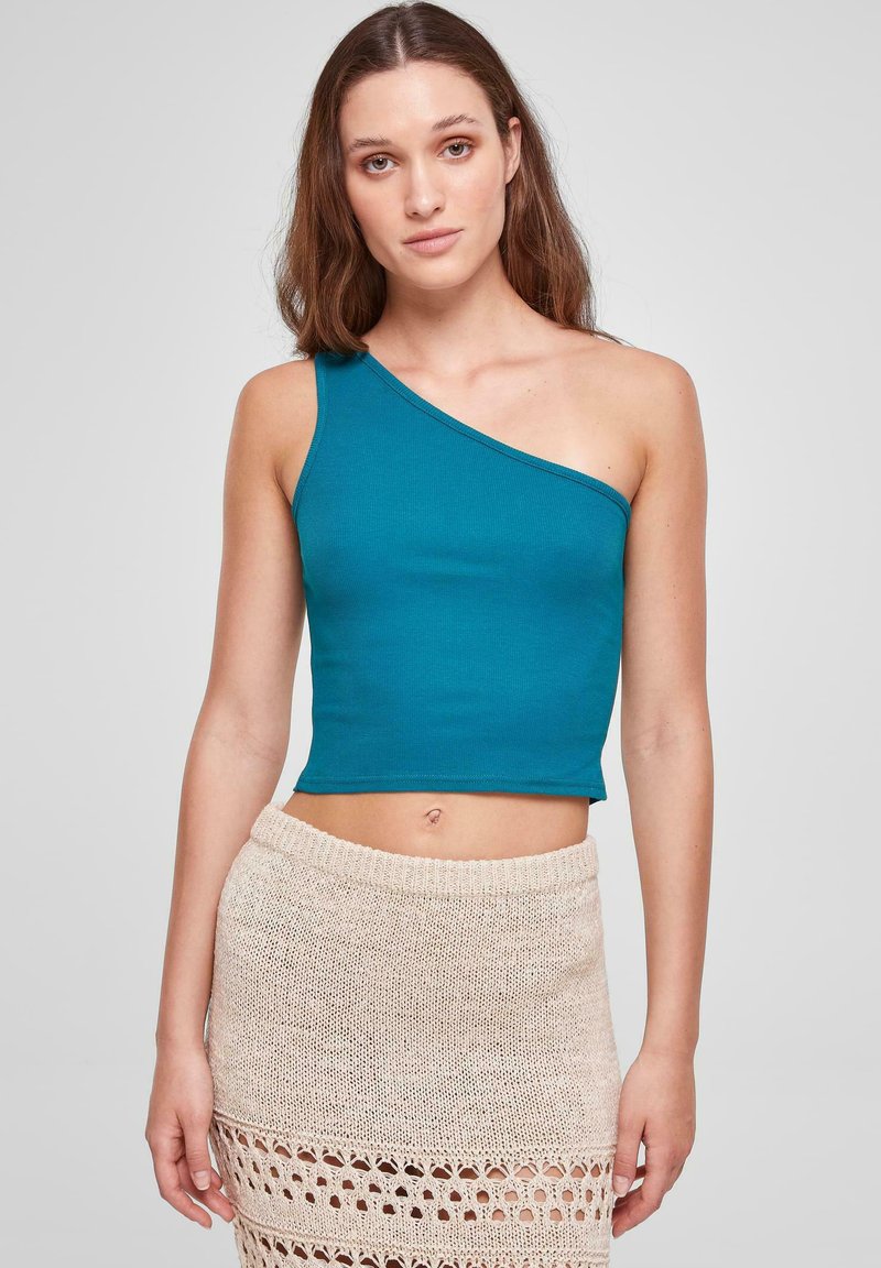 Teal en-skulder crop topp laget av glatt, elastisk stoff; har en tettsittende passform. Kombinert med et beige heklet skjørt med et teksturert mønster.