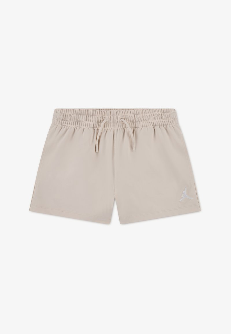 Μπεζ αθλητικό σορτς από απαλό ύφασμα, με ελαστική μέση και κορδόνι, καθώς και ένα μικρό λευκό λογότυπο στο κάτω δεξί μέρος.