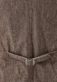 Brauner Stoffanzug mit strukturiertem Finish, in der Taille mit einem passenden Gürtel gerafft. Silberfarbene Hardware betont den Gürtel.