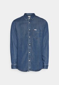 Chemise en denim bleu foncé à boutons. Elle possède un col, des manches longues, une poche poitrine et des boutons blancs. Détails de couture le long des bords.