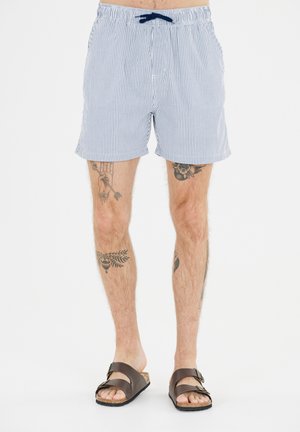 Blauwe en witte gestreepte zwembroek met een elastische tailleband en trekkoord, voorzien van zijzakken en een losse pasvorm. Bruine sandalen met gespsluiting.