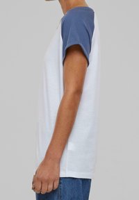 Kortærmet t-shirt med hvid krop og blå ærmer, lavet af blødt stof. Designet inkluderer en rund hals og en afslappet pasform.