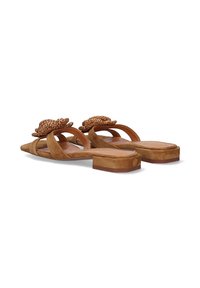 Sandalias de ante marrón con un acento floral tejido, punta abierta y tacón bajo. Diseño con tiras y detalles texturizados en la parte superior.
