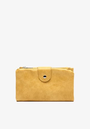 Žltá kožená peňaženka s klopou na patentný gombík a horným zipsovým priehradkom, zobrazená na bielom pozadí.
