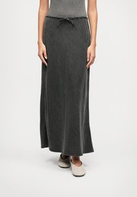 Falda maxi en gris oscuro, hecha de una tela suave con cintura elástica ajustable. Presenta un diseño simple y recto con una textura lisa.