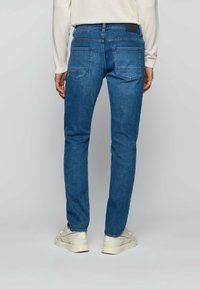 Slim-fit modré džíny z denimu, s mírným pasem, dvěma zadními kapsami a koženým logem na pasu.