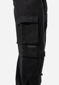 Black cargo pants made of durable fabric, featuring multiple pockets, a relaxed fit, and the brand name "PEGADOR" embroidered on the side.