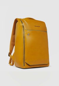 Gele leren rugzak met een gestructureerd ontwerp, voorzien van een ritsvak aan de voorkant, contrasterende blauwe accenten en gevoerde schouderbanden.