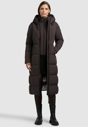 Dolga puhovka v temno rjavi barvi z quilted obliko, kapuco, sprednjim zadrgo in stranskima žepoma. Tekstilirana tkanina z gladko notranjo podlogo.