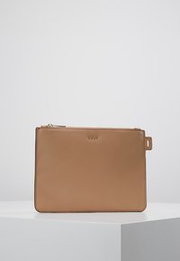 Pochette rectangulaire en cuir couleur chameau avec fermeture éclair dorée et petit logo DKNY doré centré près du bord supérieur.
