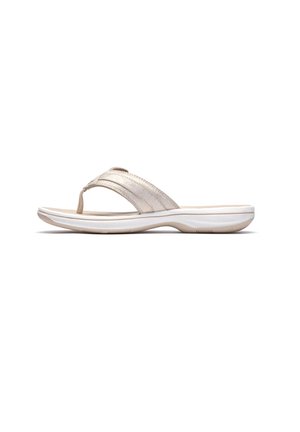 Beige Damen-String-Sandale mit gepolstertem Fußbett und konturierter weißer Sohle, entwickelt für Komfort und den lässigen Gebrauch.