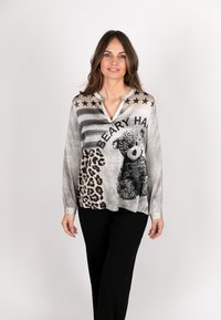Long-sleeve blouse featuring a gray and black design with leopard print, bear graphic, and star accents. V-neckline and relaxed fit.