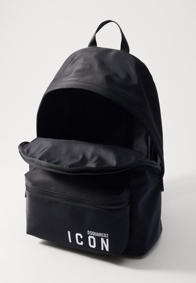 Sac à dos en nylon noir avec un dessus rond, une poche zippée à l'avant et un logo "ICON" audacieux. Texture lisse avec des bretelles ajustables et une poignée supérieure.