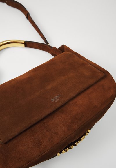 Geantă de mână din suede maro, cu formă rectangulară, buzunar plat și mânere curbate de culoare aurie. Suprafață texturată notabilă și detaliu cu logo-ul brandului.
