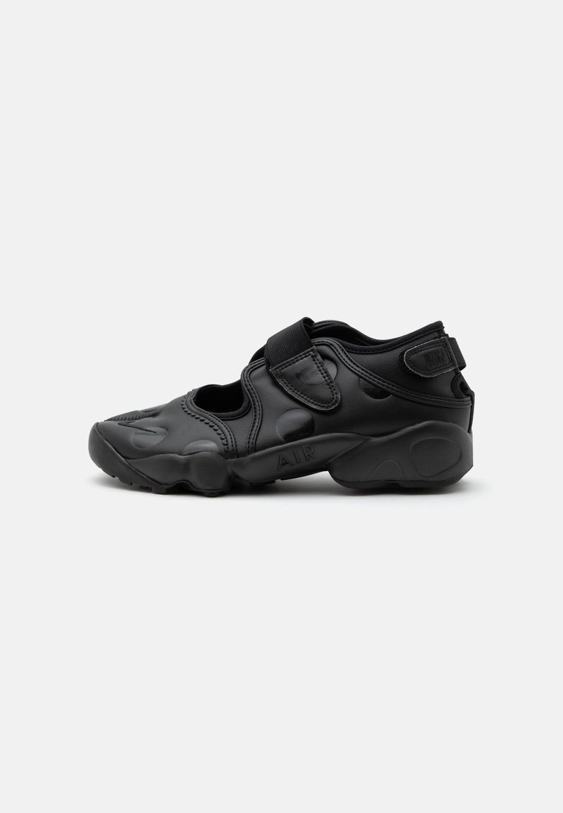 Sandale de sport noire avec bout fermé, brides Velcro au médio-pied et au talon, et semelle épaisse et rembourrée marquée "AIR" sur le côté.