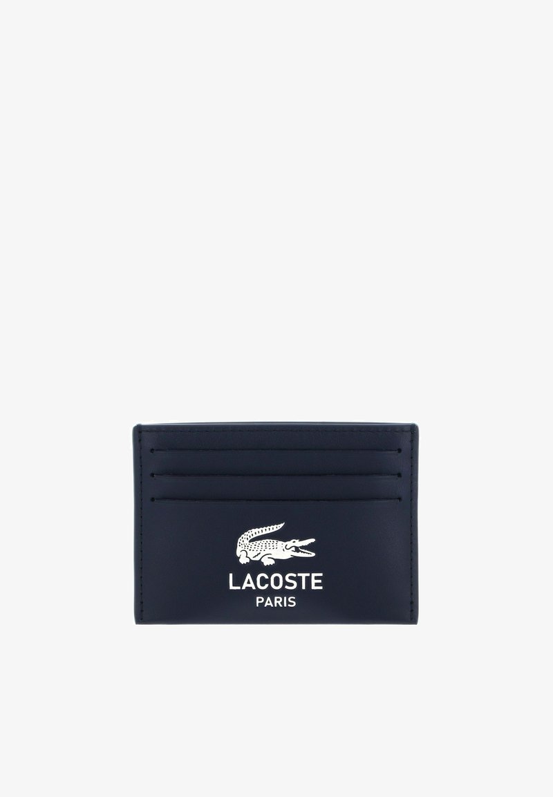 Porte-cartes noir avec quatre emplacements pour cartes et logo crocodile blanc Lacoste au-dessus du texte "LACOSTE PARIS" sur le devant.