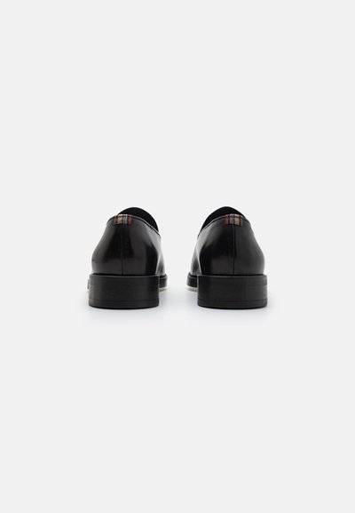 Chaussures en cuir noir avec une finition lisse, un design arrondi et une subtile touche multicolore sur le talon. Semelle en caoutchouc plate et style minimaliste.