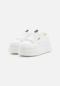 Baskets plates blanches avec une tige synthétique lisse, un design à lacets, un bout perforé et des accents de logo noirs sur la languette.
