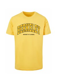 Žluté bavlněné tričko s nápisem "BERKELEY" tučným černým písmem a "UNIVERSITY OF CALIFORNIA" v menším písmu pod ním. Krátké rukávy, kulatý výstřih.