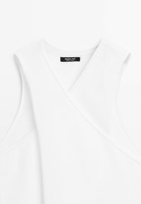 Witte gebreide mouwloze top met een V-hals en een kruis-over ontwerp aan de voorkant. Etiket leest "Massimo Dutti, Made in Spanje."