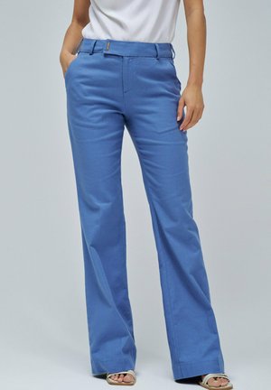 Pantalones de algodón azul con una cinturilla de panel plano, dos bolsillos laterales y un diseño de pierna amplia. Textura suave y corte ajustado.