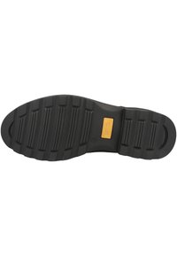 Suola di scarpa in gomma nera con superficie testurizzata, caratterizzata da scanalature orizzontali, punta arrotondata e accentuazione del logo centrale.